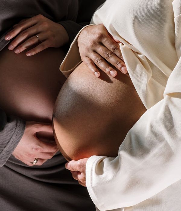 Close-up of a pregnant woman meditating with hands on her belly.