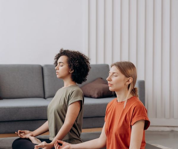 Woman practicing deep breathing exercises in a bright room.